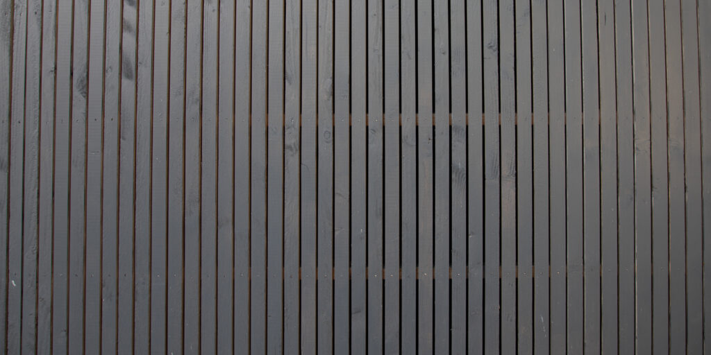 Panoramic view of dark brown stained composite fencing.